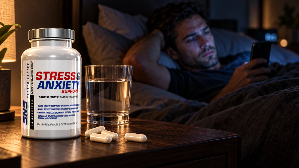 Mann liegt nachts wach im Bett mit dem Handy – Stress, Cortisol und Muskelaufbau, SNS Stress & Anxiety Support